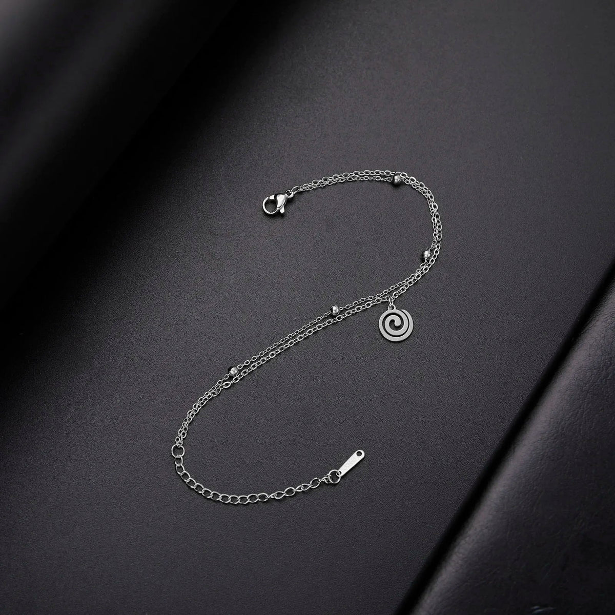 Bracelet doré avec petite breloque spirale argent