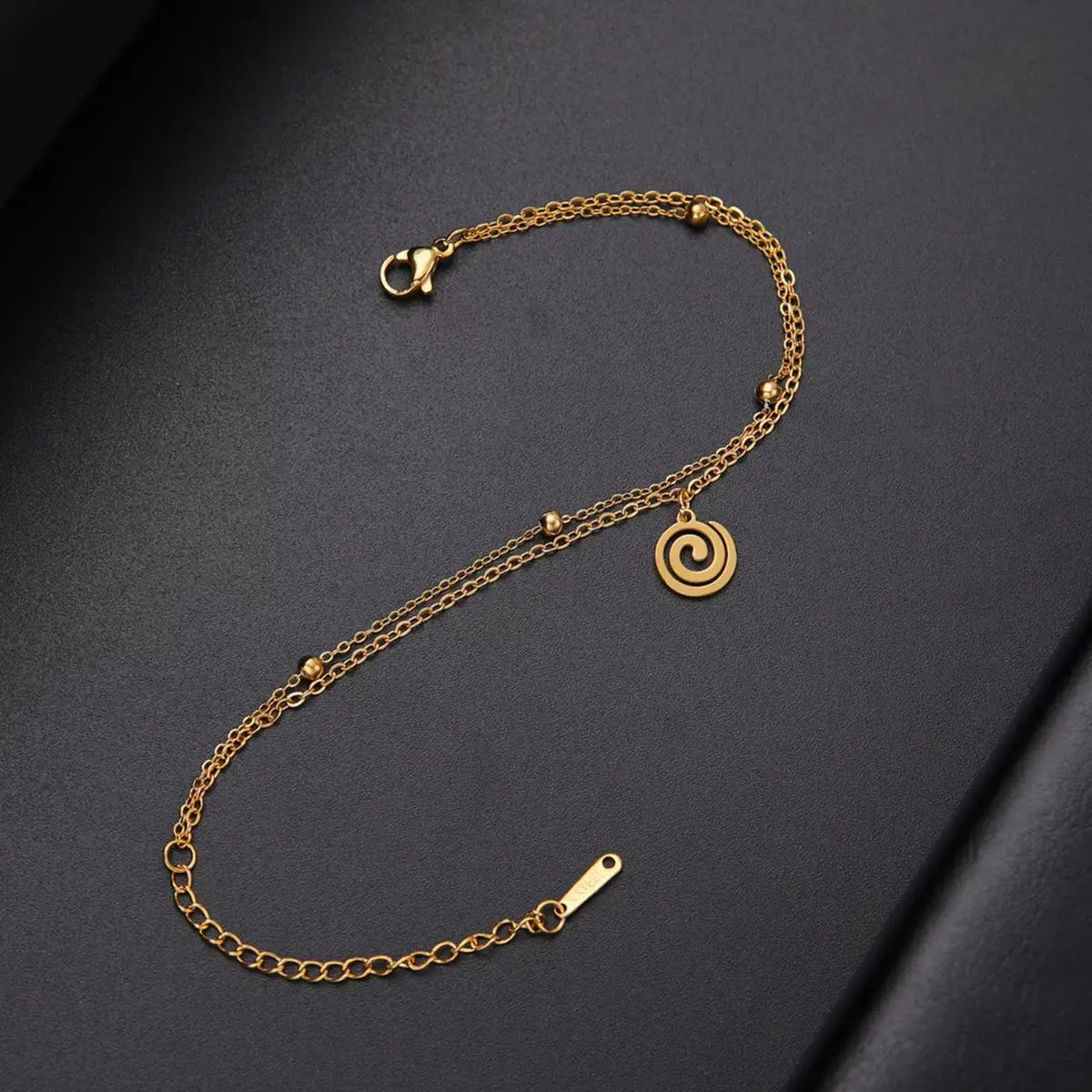 Bracelet doré avec petite breloque spirale or