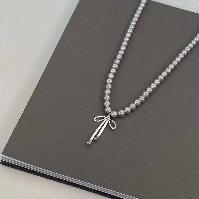 Collier Pendentif avec Perles Grises et Noeud de Papillon